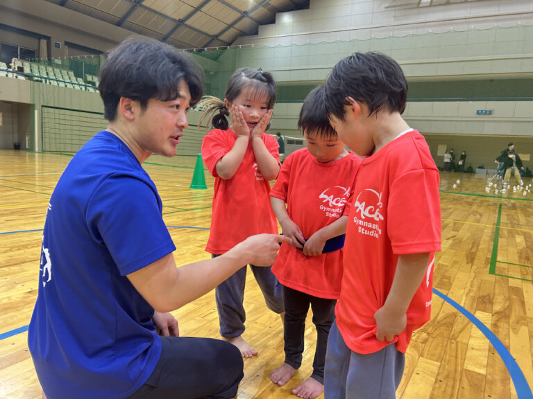 先生が子どもと目線を合わせて話す様子