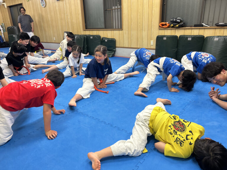 マットの上でストレッチする子どもたち