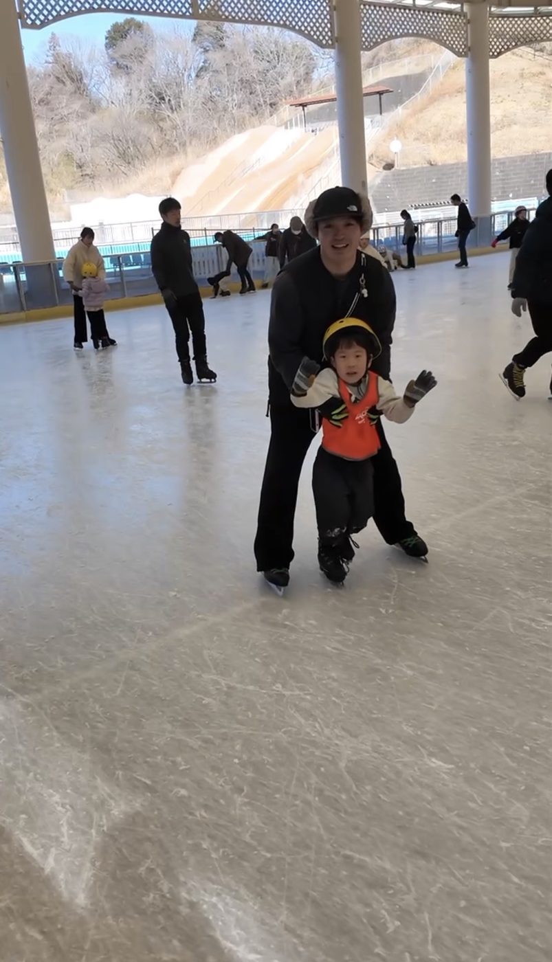 よーた先生に支えられて氷の上で手を上げる子ども
