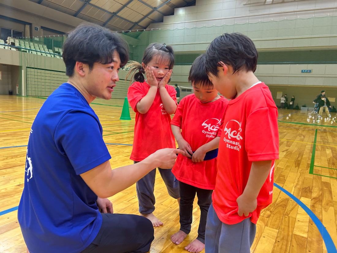 子どもと目線を合わせて話す先生