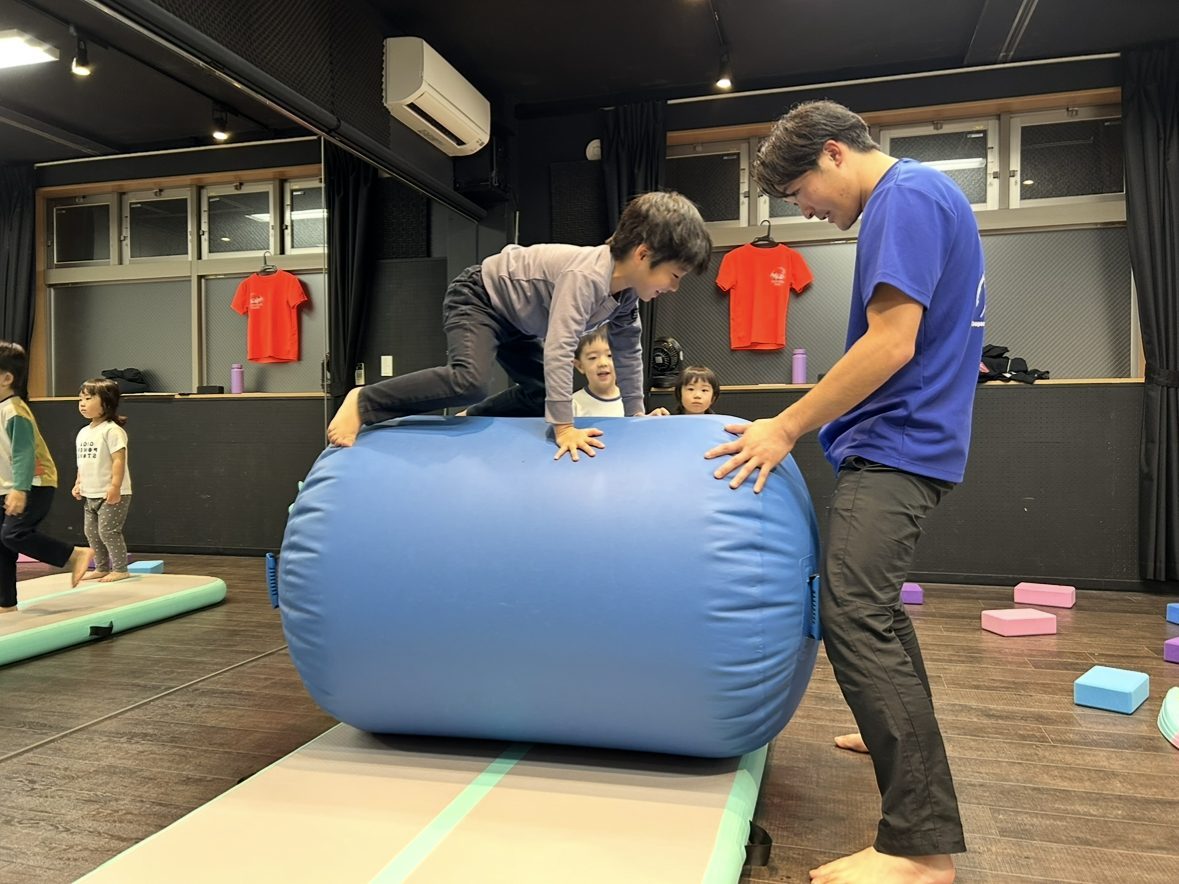 先生の補助でエアバレルを乗り越える男の子