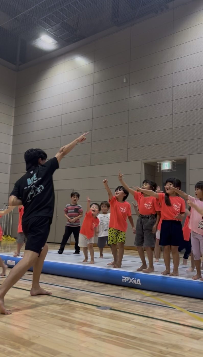 先生のまねをして手を上げる子どもたち